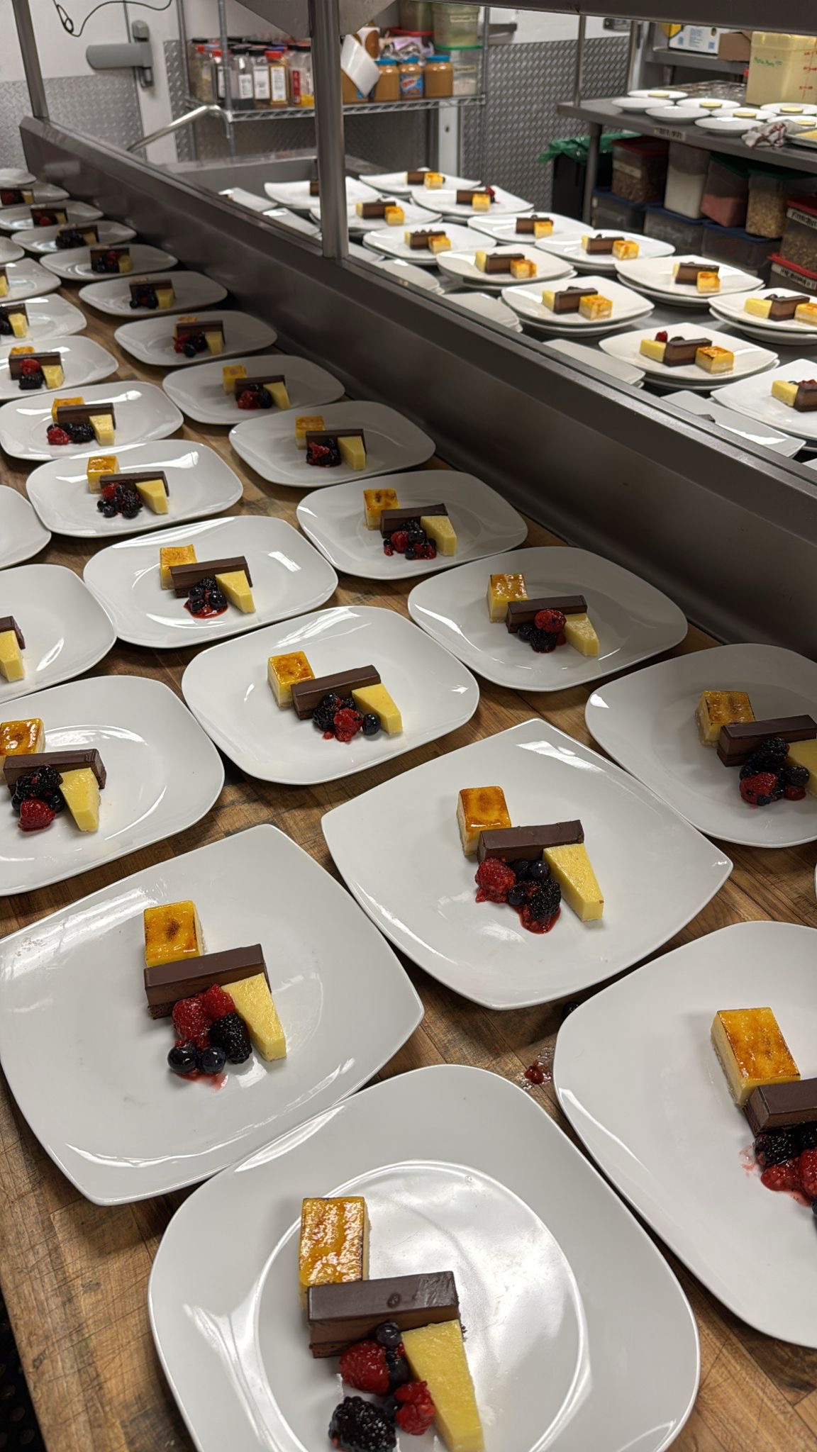 Brûlée & Ganache Bar — crème brûlée slice with dark chocolate ganache bar and mixed berry coulis for banquet